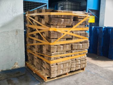 Ambardaki ahşap paletin üzerinde karton kutular var. Nakliye ve nakliye için hazır..