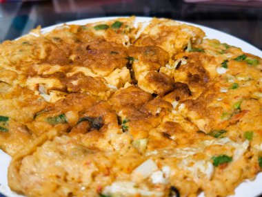 Beyaz tabakta sebzeli lezzetli bir kahverengi yumurta omletinin yakın çekimi. Lezzetli ve sağlıklı bir yemek..