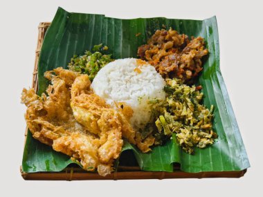 Otantik Endonezya Nasi Timbel, muz yaprağında kızarmış tavuk, sebze ve baharatla servis edilen geleneksel pirinç yemeği..