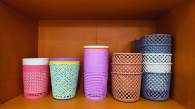 Renkli plastik depolama sepetleri ve raflarda düzgünce sergilenen konteynırlar.