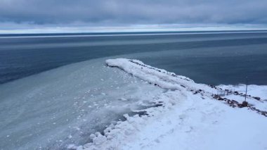 Eski bir kaya rıhtımının oluşturduğu hava görüntüsü yüzen buzu okyanus akıntıları tarafından yönlendirilen yörüngesinden sapmaya zorluyor bulutlu bir gökyüzü altında..