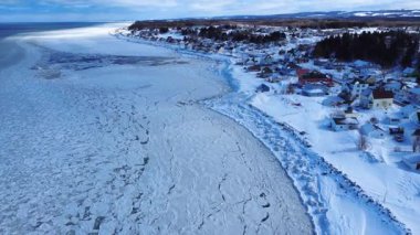 Kanada 'nın Quebec kentindeki Saint-Ulric-de-Matane kıyı köyünün buzla kaplı kıyı şeridinin panoramik hava manzarası.