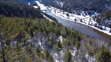 Efsanevi Matapedia Somon Nehri ve Routhierville Kapalı Köprüsü 'nün havadan görünüşü. Karla kaplı dağlardan, nehir boyunca giden birkaç arabayla yola kadar. Quebec, Kanada, 2025.