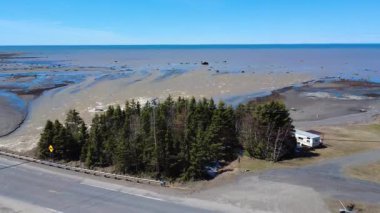 Tartigou Nehri 'nin ağzı, Kanada, Quebec, 2025' te, alçak gelgitte, St. Lawrence Nehri 'nin mavi sularına dökülen bahar selleriyle tonlarca su kahverengiye döndü.