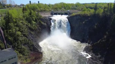 Bereketli bitki örtüsüyle çevrili büyük bir şelalesi olan bir hidroelektrik santralinin nefes kesici görüntüsü. Mitis-1 Baraj, Fiyat, Quebec, Kanada.