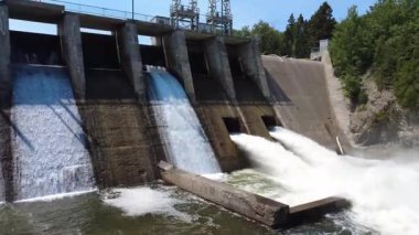 Hidroelektrik bir baraj çıkış borularından taşar, tahliye vanaları betonda ince çağlayanlar oluşturur. Mitis-2 Üretim İstasyonu, Price, Quebec, Kanada.