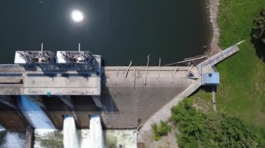 Hidroelektrik bir baraj yapısının hava manzarası. Kapıları açık, su püskürtüleri ve şelaleler oluşturuyor. Güneş rezervuardan yansıyor. Mitis-2, Price, Quebec, Kanada.