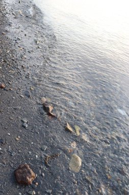 Kayaların, gökyüzünün, deniz suyunun ve gün batımında sahilin resimleri.