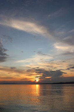 Kayaların, gökyüzünün, deniz suyunun ve gün batımında sahilin resimleri.