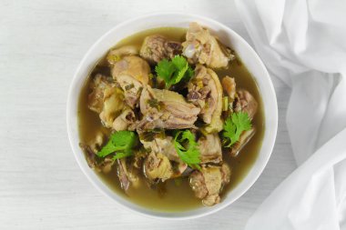 Galangal soslu ev yapımı tavuk çorbası, beyaz kasede limon otu..