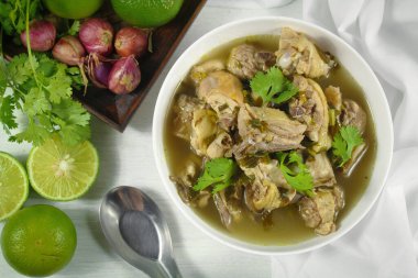 Galangal soslu ev yapımı tavuk çorbası, beyaz kasede limon otu..