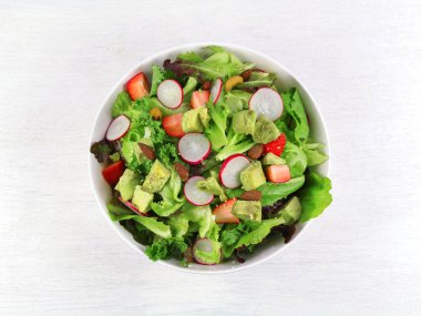 Beyaz arka planda taze sebzeli yeşil marul salatası.