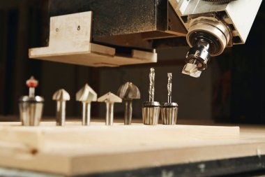 Cnc makinesi çalışıyor, odun kesiyor. Ahşap endüstrisi. Bilgisayar sayısal kontrollü aygıt, çeşitli yönlendirici bitleri.