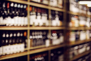 Raflardaki şarap şişelerinin bulanık fotoğrafı.