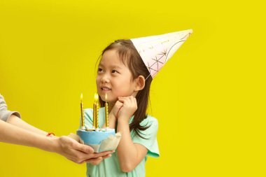 Rüya gibi doğum günü anı: Pastası ve Dilekleri olan çocuk. Küçük kız ellerini yüzünün önünde kavuşturdu ve annesine şefkat ve sevgi dolu bir bakışla baktı. O da ona sevgisini sundu.