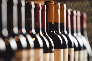 Raflarda seçkin içkiler bulunan şarap mahzeni. Farklı pahalı alkollü içeceklerle dolu bir arka plan.