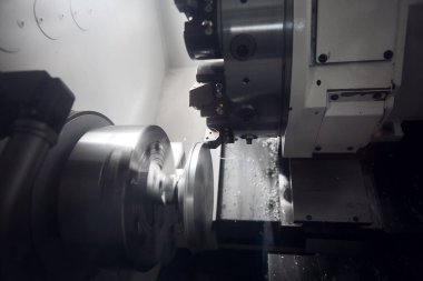 Dönme ve değirmen makinelerini metal bir şaftta kesme oluğu. CNC torna tezgahında yüksek teknoloji ürünü parçalar üretiliyor. Endüstriyel modern teknolojiler.