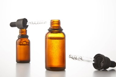 Cam ambalajlar, farklı boyutlardaki konteynerler serum, çiçek suyu, parfüm, temel yağlar, beyaz arka planda kimyasal, ilaç ürünleri için pipetler. Yan görüş. Boşluğu kopyala.