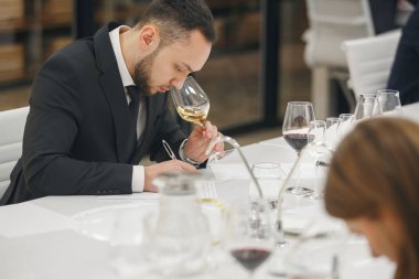 Şarap okulunda ders çalışırken şarap içen genç bir şarap garsonu. Şarap üreticileri kursları, şarap garsonları derneği. 