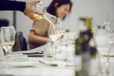 Profesyonel şarap tatma sırasında beyaz şarap dökme sahnesini yakından çek. Alkollü içecekler için şarap garsonu ve personel eğitimi. Profesyonel iş sertifikası sınavı. Şarap okulu, konferans.