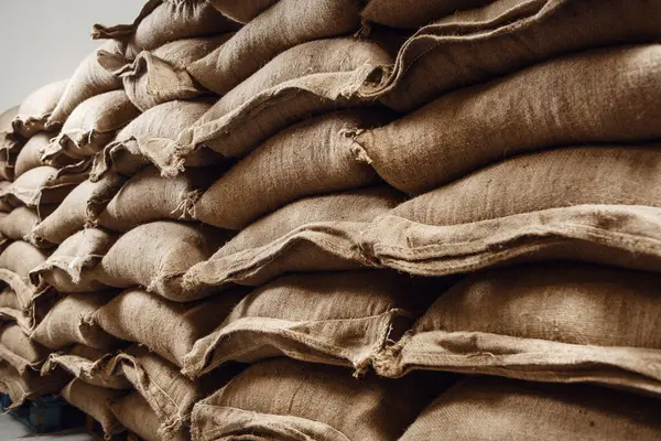 stock image Warehouse is filled with neatly stacked jute bags, all packed with fresh green coffee beans, awaiting processing for roasting and sale.