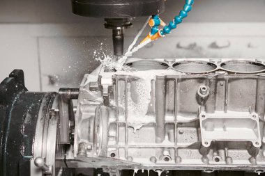 Yüksek hassasiyetli cnc değirmen makinesi soğutucu ile araba motorunda delikler açar. Metal işçiliği, modern teknolojiler.. 