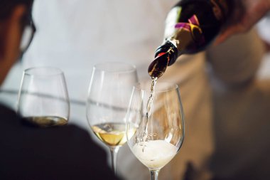 Sommelier değerlendirmesi için taze beyaz şarap dolduruyorum. Yeni başlayanlar ve tecrübeliler için şarap garsonluğu dersleri. Dünya çapında sertifika almak için eğitim ve muayene.