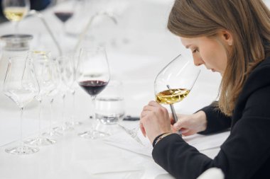 Şarap okulu eğitimi sırasında şarap içen kadın şarap garsonu beyaz şarap. Alkolik içecekler deguasyon kursları. Şarap yapma okulu, şarap garsonu sertifikası. Profesyonel şarapçılar birliği.