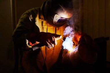 Man in protective mask welding metal construction. Industry and production. clipart