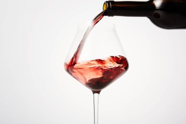 Kırmızı şarap kehribar cam şişeden eğik şarap kadehine dökülüyor. Kırmızı alkollü içecek aperatif ya da sindirim olarak servis edilir. Parti için gül suyu, kutlama. Mesaj için yer. Yan görüş. Kapat..