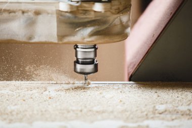 Marangozluk atölyesindeki Cnc makinesi. Çeşitli yönlendirici parçalarla odun kesiyor. Ahşap endüstrisi.