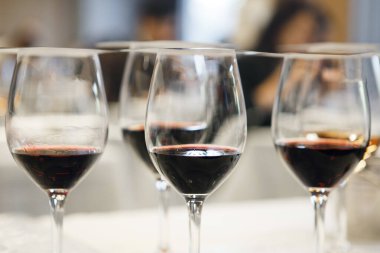 İçki sertifikası kursunda kör tadım için hazırlanmış kırmızı şarap kadehleri. Şarap okulu, konferans. Yeni başlayanlar ve tecrübeliler için şarap garsonluğu dersleri.