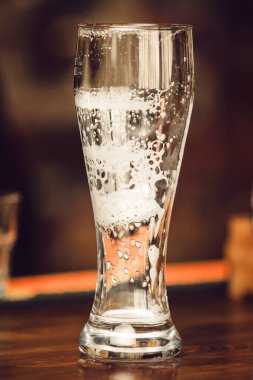 Boş bir bardak bira yan tarafına yapışmış köpük kalıntısı gösteriyor. Bu da yeni içtiğini gösteriyor. Bira festivali