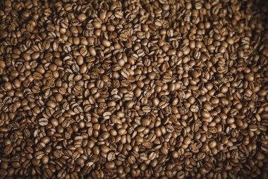 Düz yüzeyde düz bir şekilde duran aromatik kavrulmuş kahve çekirdekleri..