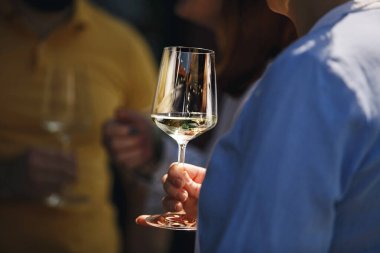 Dışarıda beyaz köpüklü şarap içen çiftlerin yakın çekimi. İçkiler eğlenceli parti konsepti. 