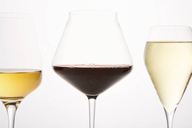 Şarap tatma, kadehten arınma, şarap yapma konsepti. Alkolik içkiler katalog, broşür, şaraphane ve dükkan için. Şampanya kadehleri, arka planda izole edilmiş kırmızı, beyaz içecekler. Yan görünüm.
