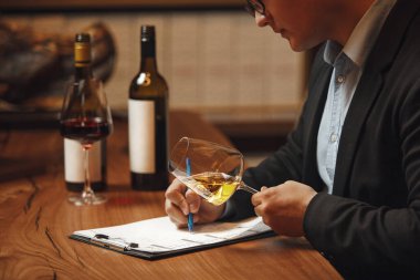 Sofrada oturan yetenekli bir şarap garsonu, şarap şişesinin yanına detaylı tarifler yazıyor, aromaları, tatları ve şarapların nüanslarını yakalamaya odaklanıyor..