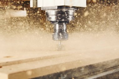 Marangozluk atölyesindeki Cnc makinesi. Çeşitli yönlendirici parçalarla odun kesiyor. Ahşap endüstrisi.