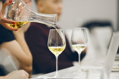 Şarap okulunda şarap şişesinden beyaz şarabı cama çevirmek. Dünya çapında sertifika almak için eğitim ve muayene. Sommelier kursları.