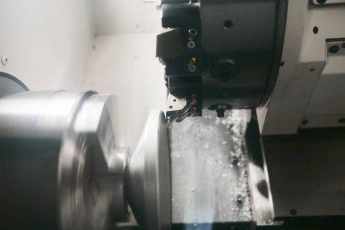 Tabanca başlı sayısal olarak kontrol edilen makine metal bir elementi öğütüyor. Dönme ve değirmen makinelerini metal bir şaftta kesme oluğu. CNC 'deki parçaların yüksek teknoloji üretim süreci