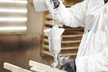 Adam ahşap boya öncesi boya püskürtme içine dökülen. Püskürtme için çözüm hazırlanması.