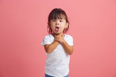  Çocuk sağlığı sorunu ve boğaz ağrısı. Hüsrana uğramış küçük bir kız boğazını tutuyor ve öksürüyor. Diline yapışmış, acı çekiyor ya da astım krizi geçiriyor..