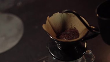 V60 Kahve Açma Süreci ve Sıcak Su. Sıcak su, V-60 damlasıyla yavaşça öğütülmüş kahveye dökülüyor. Gaz kaçarken gelişen bir etki yaratıyor..