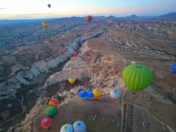 Türkiye 'nin başkenti Kapadokya' nın eşsiz kayalık manzarası üzerinde uçan renkli sıcak hava balonları ünlü bir seyahat ve kova listesi macerasının güneşli manzarasında.