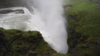 İzlanda 'daki Gullfoss şelalesini yavaş çekim görüntüsü büyük miktarlarda suyun kanyona dalışını gösteriyor. Sis havaya yükseliyor, bu doğal harikanın ham gücünü ve destansı boyutunu ortaya çıkarıyor..