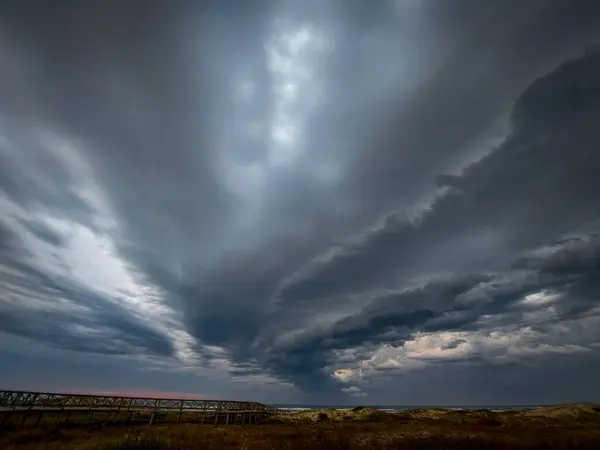 Kum tepeleri ve dramatik bulutlu gökyüzü ile doğal manzara sessizliği ve sonsuzluğu çağrıştırıyor..
