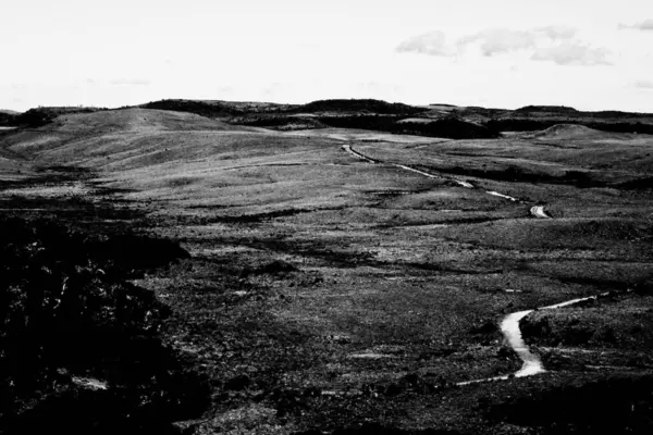Kirli yol, siyah ve beyaz bir manzarada boş tepelerde esiyor. Yalnızlık ve sonsuzluğu çağrıştırıyor..