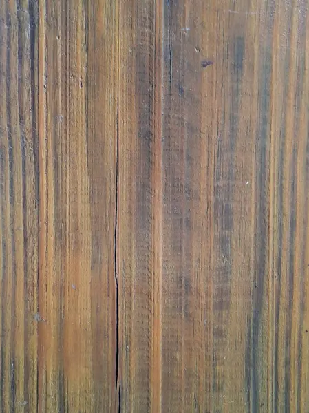 İyi tanımlanmış dikey çizgilere sahip ahşap doku, kırsallık ve basitliği çağrıştıran doğal bir çatlak ve sıcak tonların altını çiziyor..