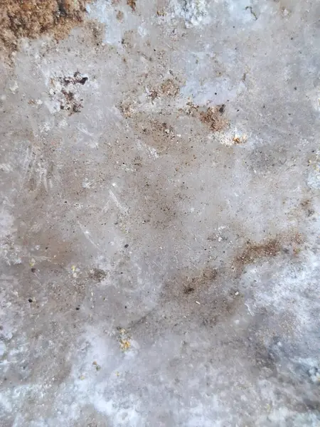 Çamur izleri, pas lekeleri ve yıpranma izleri olan metal yüzey, yaşlanmış ve kırsal bir görünüm sergiliyor..