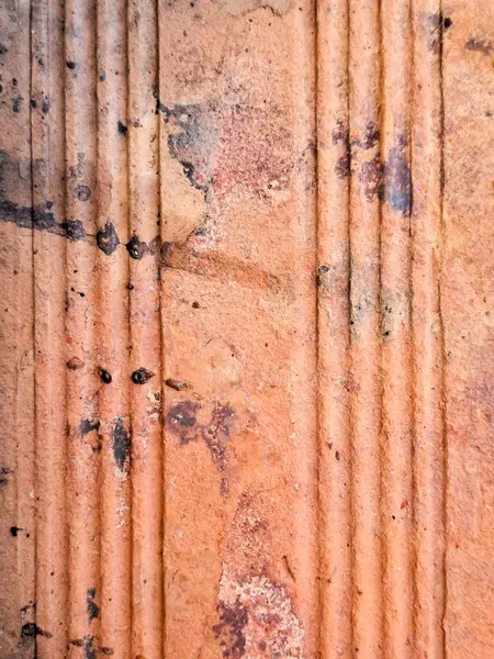 Dikey oyuklar, lekeler ve doğal aşınmalar içeren kaymayan seramik fayansların yakın plan görüntüsü, kabartma ve kırsal yüzeyi vurguluyor..